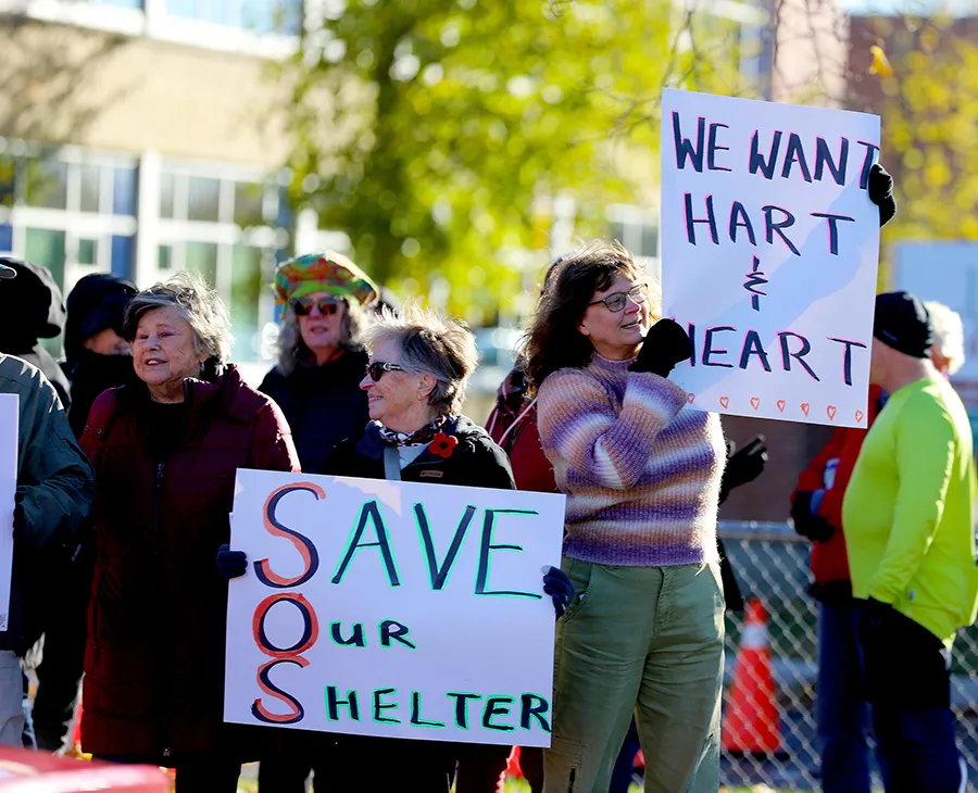 Protesters hold up signs supporting the Co-Operative Care Centre while traffic drives past the United Counties of Leeds and Grenville building on Tuesday morning, Nov. 4, 2025.